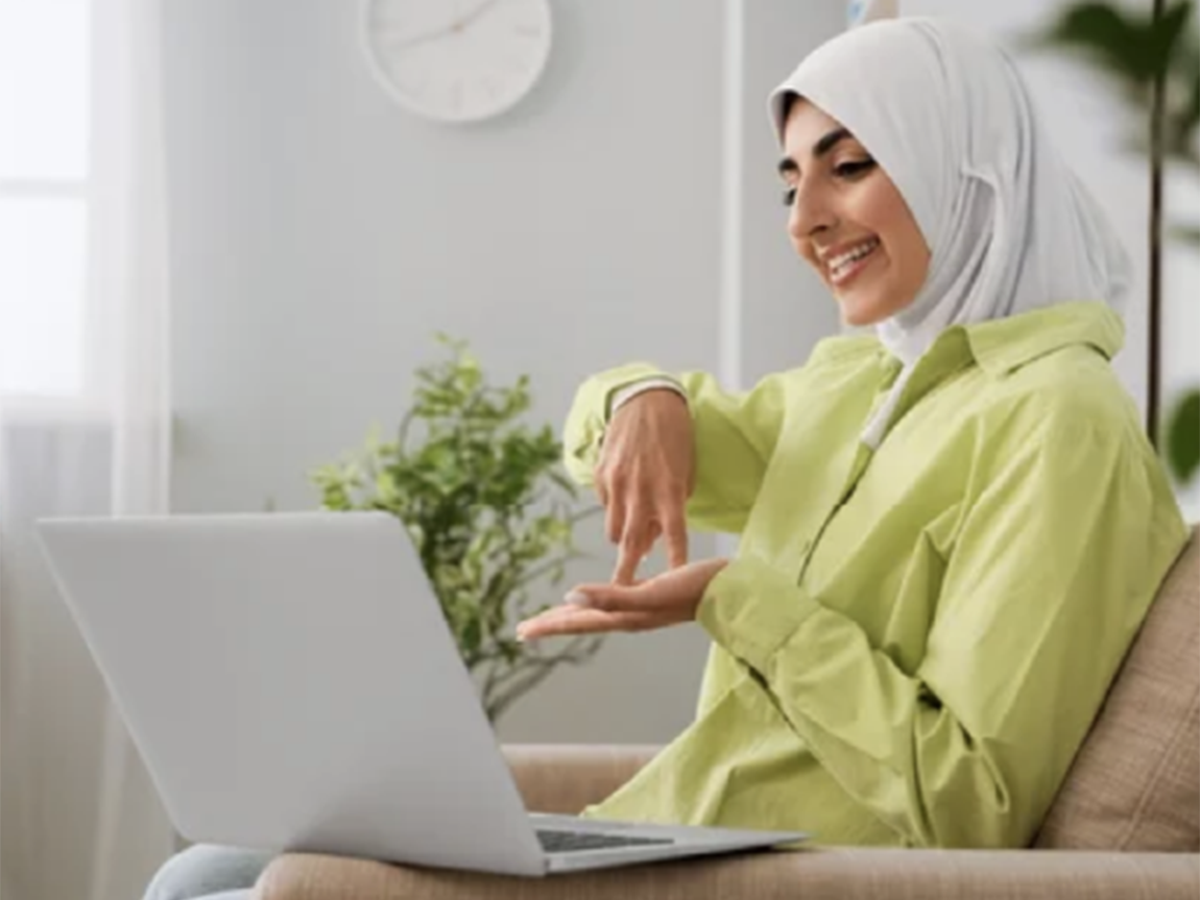 Women with hijab signing to laptop